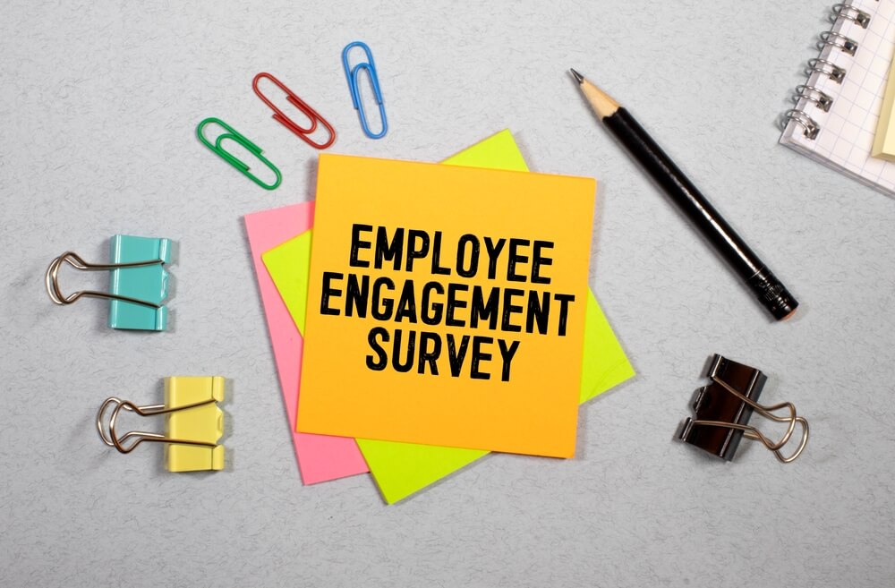 EMPLOYEEENGAGEMENTSURVEYと書かれた黄色の付箋と文房具