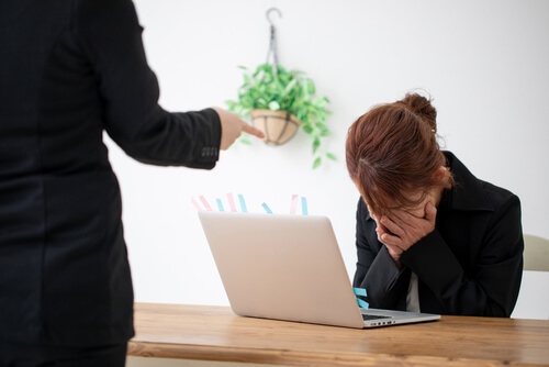 チームの前で怒鳴られている女性