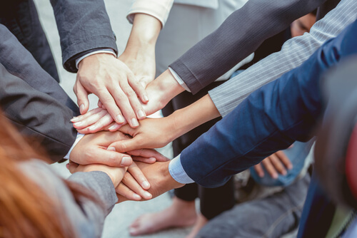 大勢の社員が一致団結して円陣を組んでいる様子