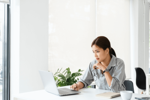 白を基調とした部屋でpc作業をする女性