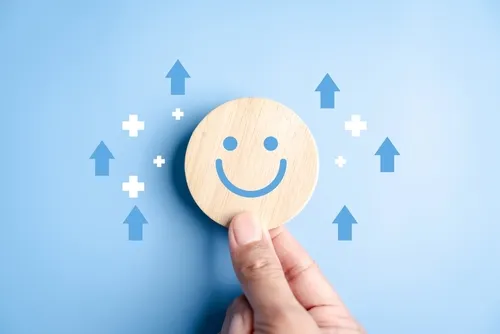 水色の背景に回復を表す矢印と笑顔のマークを持つ手元