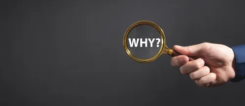 虫眼鏡でWHY?と描かれた文字を見ている様子