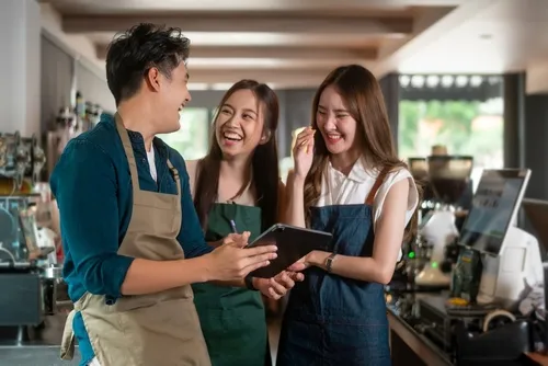 エプロンをつけた店員達が楽しげに笑う様子