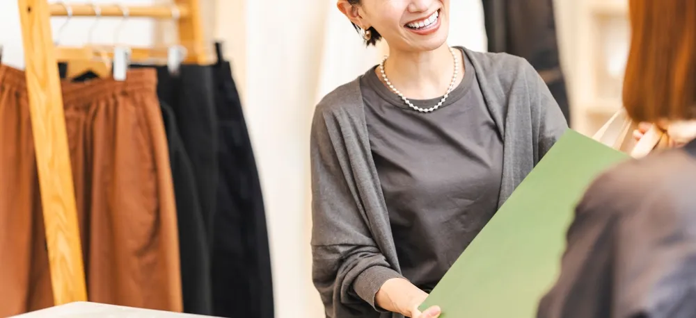 アパレル店員が、商品を渡す様子