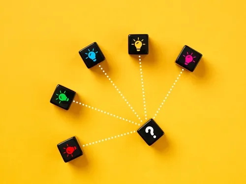 黄色い背景に電球やクエスチョンマークが描かれた黒いサイコロが並ぶ