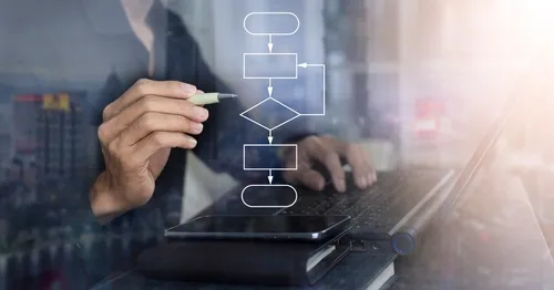 PCを見ながら空中でペンに図をイメージする人