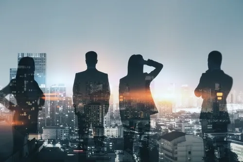 ビル街の夜景に浮かぶ複数人の影