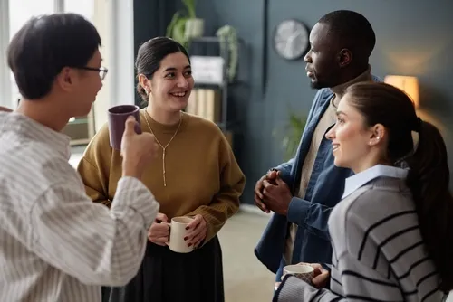 マグカップを片手に語り合う4人の男女