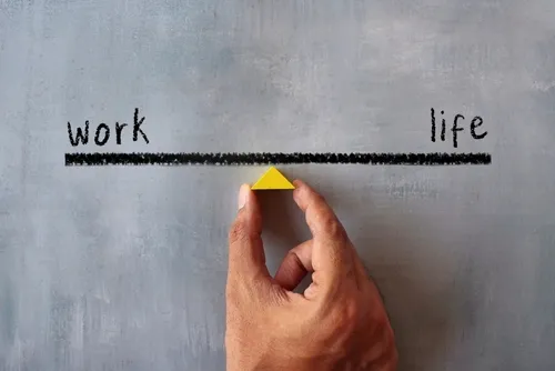 仕事と人生を天秤にかけるイラストの真ん中を持つ手元