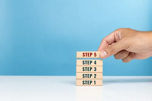 STEP1〜5が描かれた積み木を重ねる手元