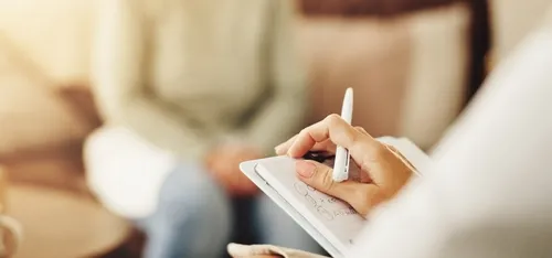 メモをとるカウンセリングの先生