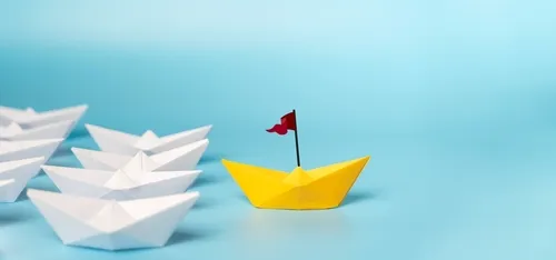 水色の背景に白や黄色の折り紙の船が並ぶ