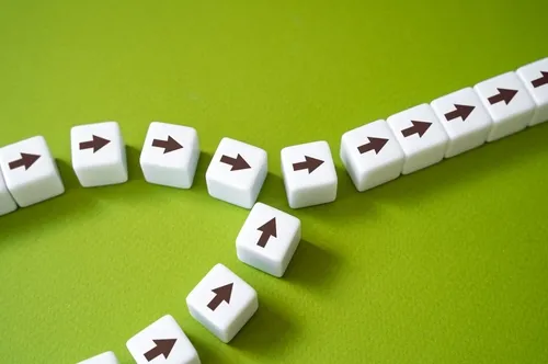 黄緑色の背景の上に並ぶ、矢印が描かれたたくさんのサイコロ