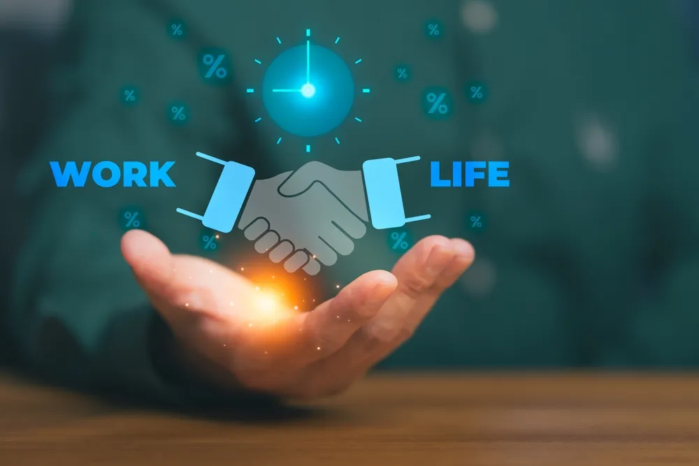 広げる手のひらの上で光る仕事と人生を表した手が握手する様子