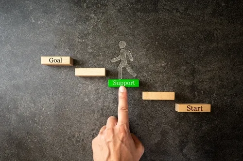 コンクリート調の背景にスタートからゴールまでの階段を登る人をサポートする手元