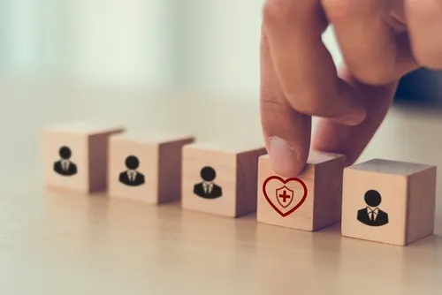 スーツの人や心の病院のようなマークが描かれたサイコロを並べる手元