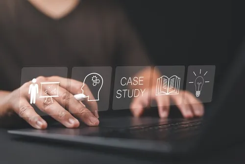 空間に浮かぶ電球や本が描かれたイラストと黒いPCを触る人