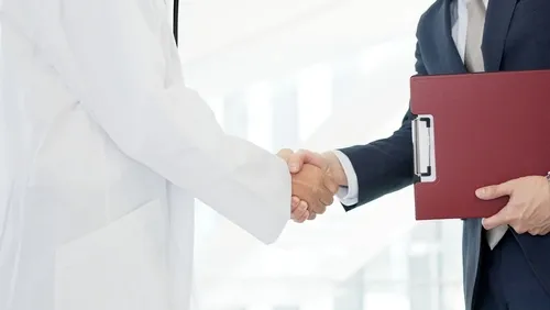 スーツを着た人と握手をする医師