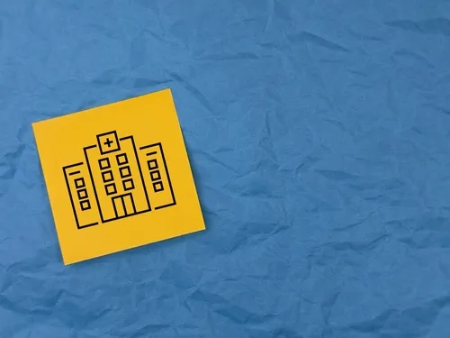 シワのある青い紙の上にある黄色の病院のイラスト