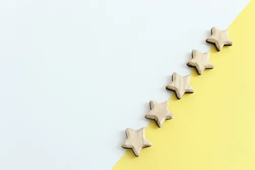 黄色と白の背景に木製の星が並ぶ