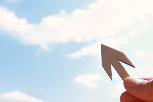 空に向かって矢印を向ける手元