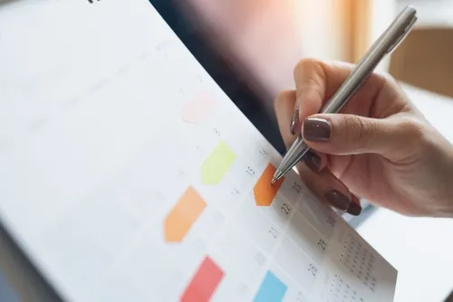 スケジュールに付箋を貼り、書き込む手元