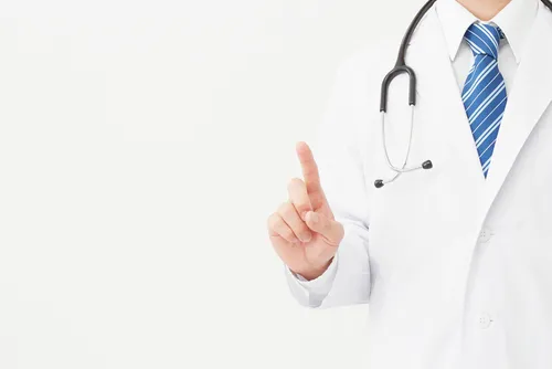 人差し指を立てた白衣を着た医師