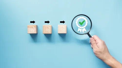 チェックがついている木のブロックと認定マークを映す虫眼鏡