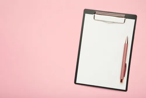 ピンクの背景にバインダーとペン
