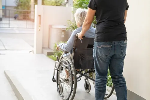 車椅子の老人を押す人