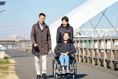 車椅子の女性に話しかける男女